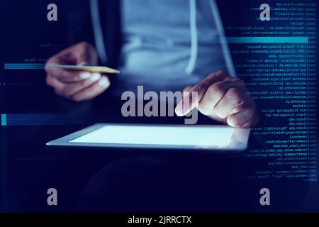 Alles, was du hast, gehört jetzt mir. Ein nicht identifizierbarer Computerhacker, der im Dunkeln ein Tablet benutzt. Stockfoto