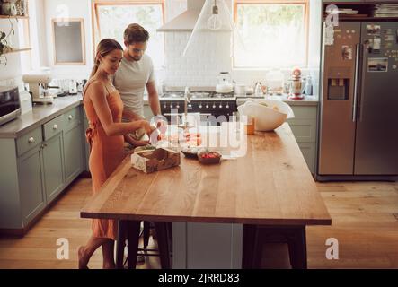 Paar kochen, zu Hause essen oder gesunde Mahlzeit für die Bindung, glücklich oder Spaß Mann und Frau in der Hausküche zusammen. Gespräch, Liebe oder junge Menschen in Stockfoto