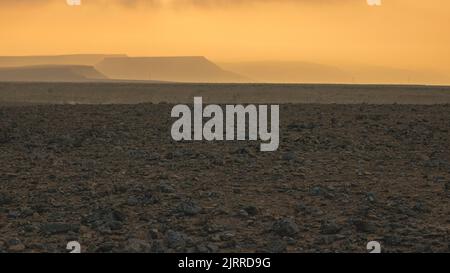 Die aufgehende Sonne verbrennt den Morgennebel in Israels südlicher Negev-Wüste. Stockfoto