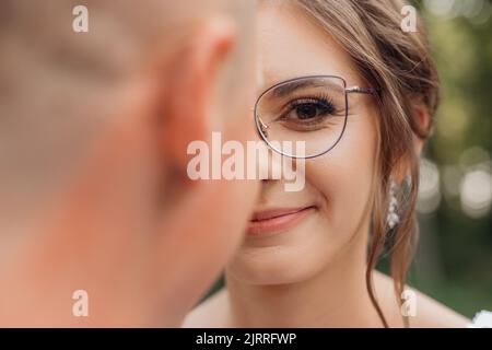 Nahaufnahme Porträt aufgeregt, lächelnd, frech lockig haarige Frau in modernen Brillen mit Rand Blick auf die Kamera. Schlechte Sicht Stockfoto
