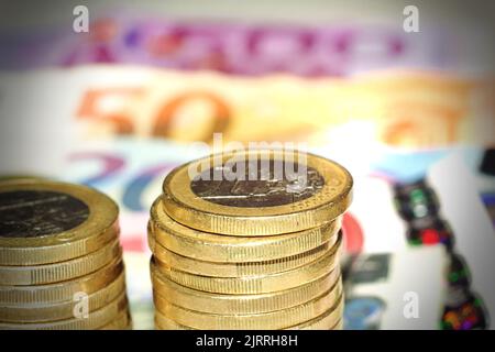 Nahaufnahme von Euro-Münzen mit Euro-Scheinen als Hintergrund. Stockfoto
