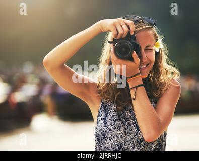 Schön Jetzt halten, dass Pose...Porträt einer jungen Frau, die Fotos mit ihrer Kamera am Strand. Stockfoto