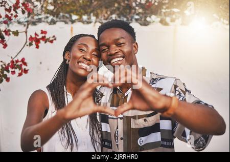 Glückliches Paar Herz Liebe Zeichen mit ihren Händen posieren für ein Bild oder Foto während im Urlaub oder Urlaub. Porträt eines liebenden und jungen Afrikaners Stockfoto