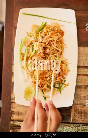 Pad thai jeder. Eine Person, die eine Schüssel Pad thai in einem Restaurant in Thailand isst. Stockfoto