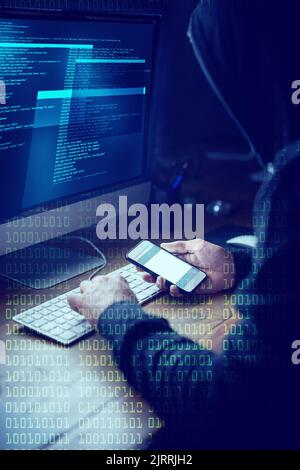 Smartphones sind willige Komplizen der Cyberkriminalität. Ein nicht identifizierbarer Computerhacker, der einen Computer im Dunkeln benutzt. Stockfoto