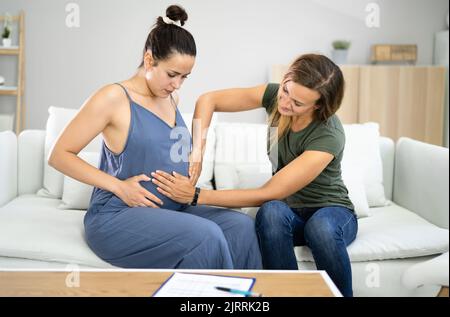 Schwangeren Massage Von Doula. Babypflege Und Schwangerschaftsdienst Stockfoto