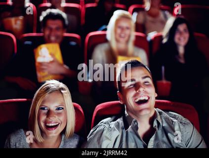 Paar im Kino Kino Kino für lustige, komische und glückliche Filmshow im Zuschauerraum auf einem Date. Lächle, entspanne dich und lache den Leuten, die Comedy gucken Stockfoto