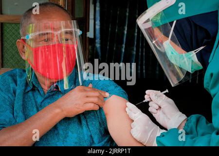 Temanggung, Central Java, Indonesien, 23. September 2021: Medizinische Mitarbeiter bereiten Injektionen des Covid-19-Impfstoffs vor. Durch diese Methode wird erwartet, dass die Teilnahme an Impfungen zunehmen wird, da sie Familien erreichen kann, die keinen Zugang haben und Angst haben, das Haus zu verlassen, um die Übertragung des Virus zu vermeiden. Stockfoto