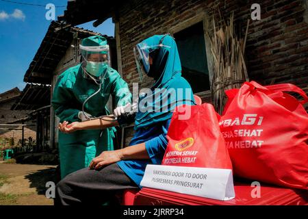 Temanggung, Central Java, Indonesien, 23. September 2021: Medizinische Mitarbeiter bereiten Injektionen des Covid-19-Impfstoffs vor. Durch diese Methode wird erwartet, dass die Teilnahme an Impfungen zunehmen wird, da sie Familien erreichen kann, die keinen Zugang haben und Angst haben, das Haus zu verlassen, um die Übertragung des Virus zu vermeiden. Stockfoto