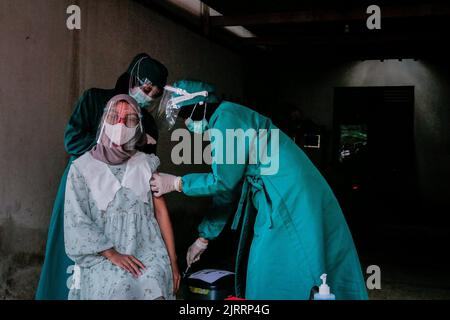 Temanggung, Central Java, Indonesien, 23. September 2021: Medizinische Mitarbeiter bereiten Injektionen des Covid-19-Impfstoffs vor. Durch diese Methode wird erwartet, dass die Teilnahme an Impfungen zunehmen wird, da sie Familien erreichen kann, die keinen Zugang haben und Angst haben, das Haus zu verlassen, um die Übertragung des Virus zu vermeiden. Stockfoto