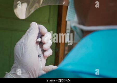 Temanggung, Central Java, Indonesien, 23. September 2021: Medizinische Mitarbeiter bereiten Injektionen des Covid-19-Impfstoffs vor. Durch diese Methode wird erwartet, dass die Teilnahme an Impfungen zunehmen wird, da sie Familien erreichen kann, die keinen Zugang haben und Angst haben, das Haus zu verlassen, um die Übertragung des Virus zu vermeiden. Stockfoto