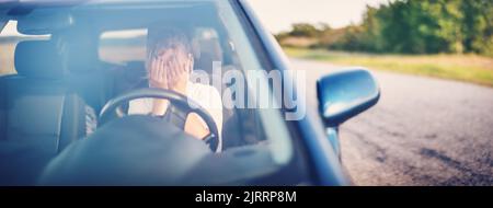 Verärgerte Frau, die im Auto sitzt und das Gesicht mit den Händen bedeckt Stockfoto