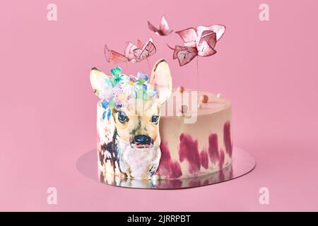 Pastellfarben leckerer Kuchen mit Schmetterlingen und Hirschen. Rosa Hintergrund. Selektiver Fokus. Stockfoto