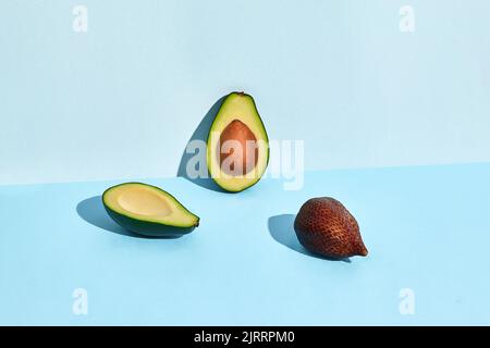 Avocado- und Salacca-Früchte auf blauem Hintergrund Stockfoto