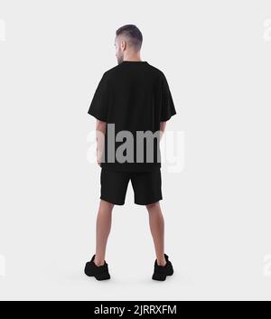 Nachbildung eines schwarzen Oversized-Anzugs auf einen Mann in Sneakers, Rückansicht, isoliert auf weißem Hintergrund. T-Shirt-Vorlage mit lockerer Passform, Shorts auf einem Standin Stockfoto