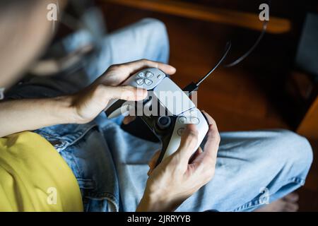 Bangkok, Thailand - 24. August 2022: Gamer spielen PlayStation 5-Spielkonsole mit DualSense-Controller. Stockfoto