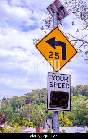 Ein Straßenschild, das auf eine Kurve der Straße und eine Geschwindigkeitsbegrenzung hinweist, und eine Geschwindigkeitskontrolle auf einer Straße in Kalifornien, USA Stockfoto