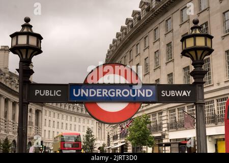 Editorial rot-blaue U-Bahn-U-Bahn-Schild am piccadilly-Zirkus mit historischen Gebäuden im Hintergrund gegen bewölkten weißen Himmel Konzept für L Stockfoto