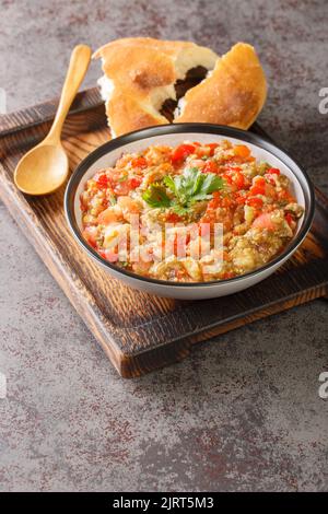 Auberginen-Kaviar mit Tomaten, Knoblauch und gerösteter Paprika-Closeup in der Schüssel auf dem Tisch. Vertikal Stockfoto