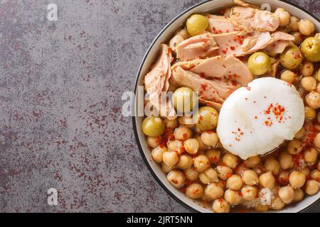 Traditionelle tunesische Kichererbsen-Suppe, serviert zum Frühstück Lablabi mit pochiertem Ei und Thunfisch in der Schüssel auf dem Tisch. Horizontale Ansicht von oben Stockfoto