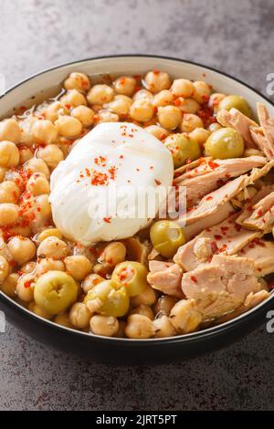 Lablabi oder Lablebi ist eine tunesische Suppe mit Kichererbsen, die über Stücken abgestandenem Brot serviert wird und mit einem pochierten Ei und Thunfisch aus der Nähe gekrönt wird Stockfoto