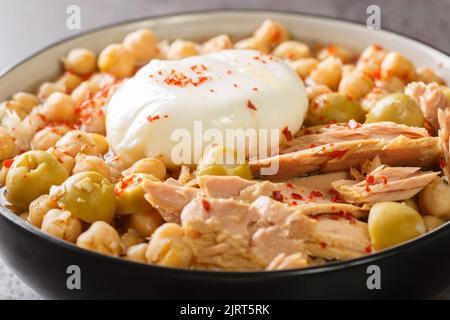 Traditionelle tunesische Kichererbsen-Suppe, serviert zum Frühstück Lablabi mit pochiertem Ei und Thunfisch in der Schüssel auf dem Tisch. Horizontal Stockfoto