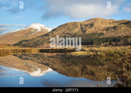 Gebiet von Crianlarich, Schottland. Malerischer Blick in die Dämmerung auf den Fluss Fillan mit einem schneebedeckten Ben More im Hintergrund. Stockfoto