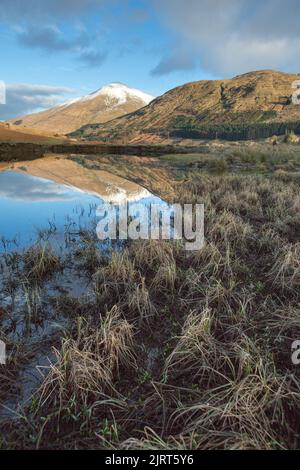 Gebiet von Crianlarich, Schottland. Malerischer Blick in die Dämmerung auf den Fluss Fillan mit einem schneebedeckten Ben More im Hintergrund. Stockfoto