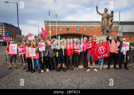 Manchester, Großbritannien. 26. August 2022. Mitarbeiter von Royal Mail versammeln sich am Streikposten, während sie am ersten Tag der Streiks Plakate und Flaggen halten. Mitglieder der Gewerkschaft der Kommunikationsarbeiter protestieren gegen die vorgeschlagene Erhöhung um zwei Prozent, die unter der Inflation und während einer Lebenshaltungskrise liegt. Kredit: SOPA Images Limited/Alamy Live Nachrichten Stockfoto