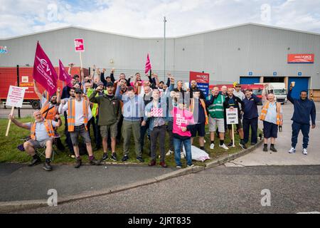 Manchester, Großbritannien. 26. August 2022. Mitarbeiter von Royal Mail versammeln sich am Streikposten, während sie am ersten Tag der Streiks Plakate und Flaggen halten. Mitglieder der Gewerkschaft der Kommunikationsarbeiter protestieren gegen die vorgeschlagene Erhöhung um zwei Prozent, die unter der Inflation und während einer Lebenshaltungskrise liegt. Kredit: SOPA Images Limited/Alamy Live Nachrichten Stockfoto