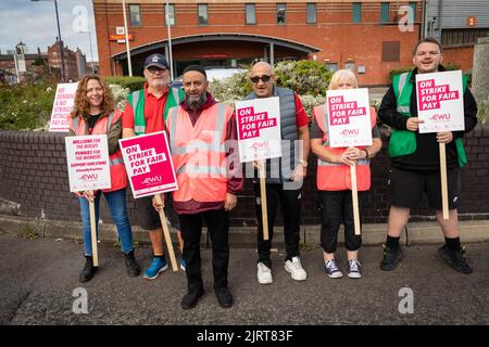 Manchester, Großbritannien. 26. August 2022. Mitarbeiter von Royal Mail versammeln sich am Streikposten, während sie am ersten Tag der Streiks Plakate halten. Mitglieder der Gewerkschaft der Kommunikationsarbeiter protestieren gegen die vorgeschlagene Erhöhung um zwei Prozent, die unter der Inflation und während einer Lebenshaltungskrise liegt. Kredit: SOPA Images Limited/Alamy Live Nachrichten Stockfoto