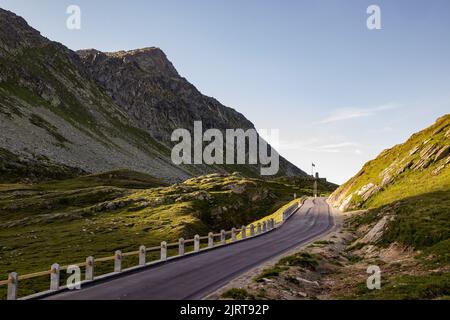 Der wunderschöne Sonnenaufgang am Splugen Pass (Grenze zwischen Italien und der Schweiz), Europa. Herrliche Bergstraße in der Morgensonne. HD Wallpaper, 4K Green backgro Stockfoto