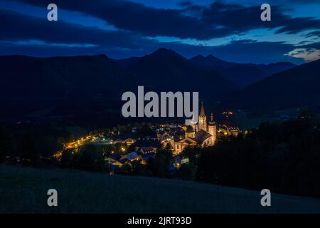 Einbruch der Dunkelheit über die wunderschöne österreichische Alpenstadt (Mariazell, Niederösterreich, Europa). HD Wallpaper, 4K Hintergrund. Blaue Stunde. Beleuchtete Häuser mit Stockfoto