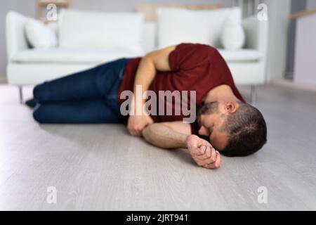 Unbewusste junger Mann lag auf dem Boden im Wohnzimmer Stockfoto