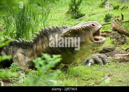 Iguanodon-Dinosaurier im Dino-Park, ZOO Vyskov, Tschechische Republik. Grüner Hintergrund HD. Hintergrund 4K. Illustrative redaktionelle Inhalte - Dinosaurier-Thema. Stockfoto