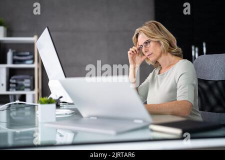 Depressive müde Dame mit PC-Computer. Verärgerte Frau Stockfoto