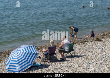 UK Wetter, East Wittering, 26. August 2022: Sonnenschein am Strand und sehr ruhiges Wasser in West Sussex machen das Feiertagswochenende im August für Familien, Sonnenanbeter, Schwimmer und Paddle-Boarder zu einem guten Tart. Die Strände von West Sussex haben nicht unter den Abwasserentladungen gelitten, die East Sussex vor kurzem hatte. Anna Watson/Alamy Live News Stockfoto