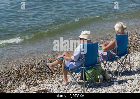 UK Wetter, East Wittering, 26. August 2022: Sonnenschein am Strand und sehr ruhiges Wasser in West Sussex machen das Feiertagswochenende im August für Familien, Sonnenanbeter, Schwimmer und Paddle-Boarder zu einem guten Tart. Die Strände von West Sussex haben nicht unter den Abwasserentladungen gelitten, die East Sussex vor kurzem hatte. Anna Watson/Alamy Live News Stockfoto