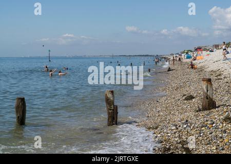 UK Wetter, East Wittering, 26. August 2022: Sonnenschein am Strand und sehr ruhiges Wasser in West Sussex machen das Feiertagswochenende im August für Familien, Sonnenanbeter, Schwimmer und Paddle-Boarder zu einem guten Tart. Die Strände von West Sussex haben nicht unter den Abwasserentladungen gelitten, die East Sussex vor kurzem hatte. Anna Watson/Alamy Live News Stockfoto