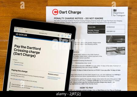 Eine Benachrichtigung über eine Strafgebühr für die Nichtentrichtung der Dart-Gebühr am Dartford Thurrock Thames Crossing. Mit Zahlungs-Website auf dem ipad angezeigt. Stockfoto