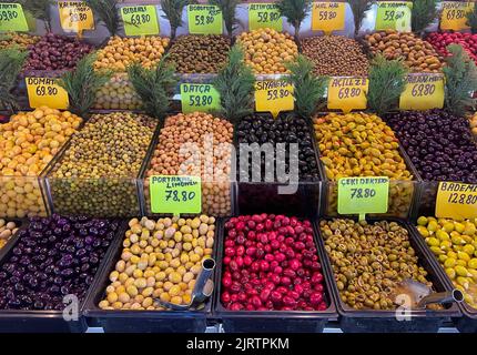 Verschiedene Oliven zum Verkauf an einem Marktstand, verschiedene bunte Oliven Reihen sich an der lokalen Markttheke an. Stockfoto