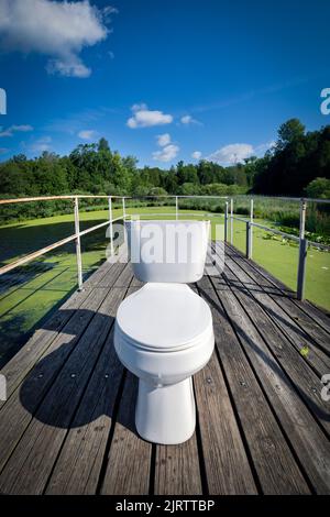 Eine Toilette befindet sich auf einem hölzernen Pier am Gass Lake in der Nähe von Manitowoc, Wisconsin. Stockfoto