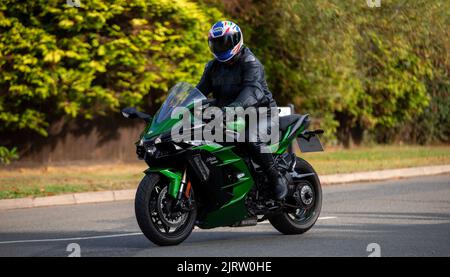 Mann in schwarzem Leder auf einer grünen Kawasaki Ninja H2 SX Stockfoto