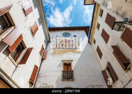 Mittelalterlicher Turm in der Stadt Spilimbergo (westlicher Turm) mit dem geflügelten Löwen des Heiligen Markus und Wappen der Herren von Spilimbergo. Friaul, Italien. Stockfoto