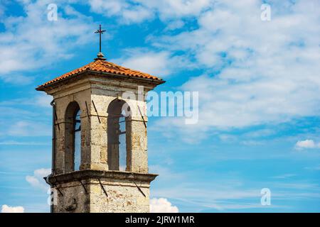 Antiker Glockenturm einer kleinen Kirche mit blauem Himmel und Wolken (Chiesa della Beata Vergine della Mercede oder dell’Anconica), 1687. Spilimbergo. Stockfoto