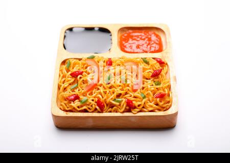 Instant Nudeln mit Sojasauce und Gewürzsauce in Schüssel isoliert auf weißem Hintergrund. Draufsicht. Stockfoto