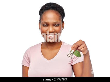 afrikanische Frau mit grünem Blatt und Hausschlüssel Stockfoto