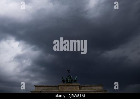 Berlin, Deutschland. 26. August 2022. Dunkle Wolken ziehen über die Quadriga des Brandenburger Tors. Quelle: Christoph Soeder/dpa/Alamy Live News Stockfoto