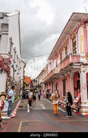 Phuket, Thailand - Juli 2022: Menschen, die entlang der Soi Rommani Street in der Altstadt von Phuket spazieren, die für ihre farbenfrohen Häuser bekannt ist. Stockfoto