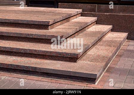 Ecktreppe aus Granit mit Steintreppen steigen auf die Schwelle Gebäude Fassade Architektur close-up Steindetails von der Sonne beleuchtet, niemand. Stockfoto